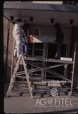 Obreros colocando el cartel de la Fundación Laboral de la Construcción