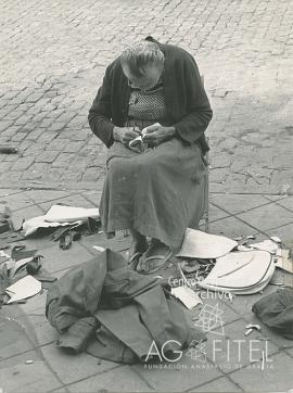 Anciana cosiendo en la calle