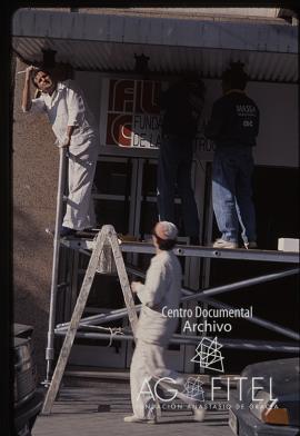 Obreros colocando el cartel de la Fundación Laboral de la Construcción